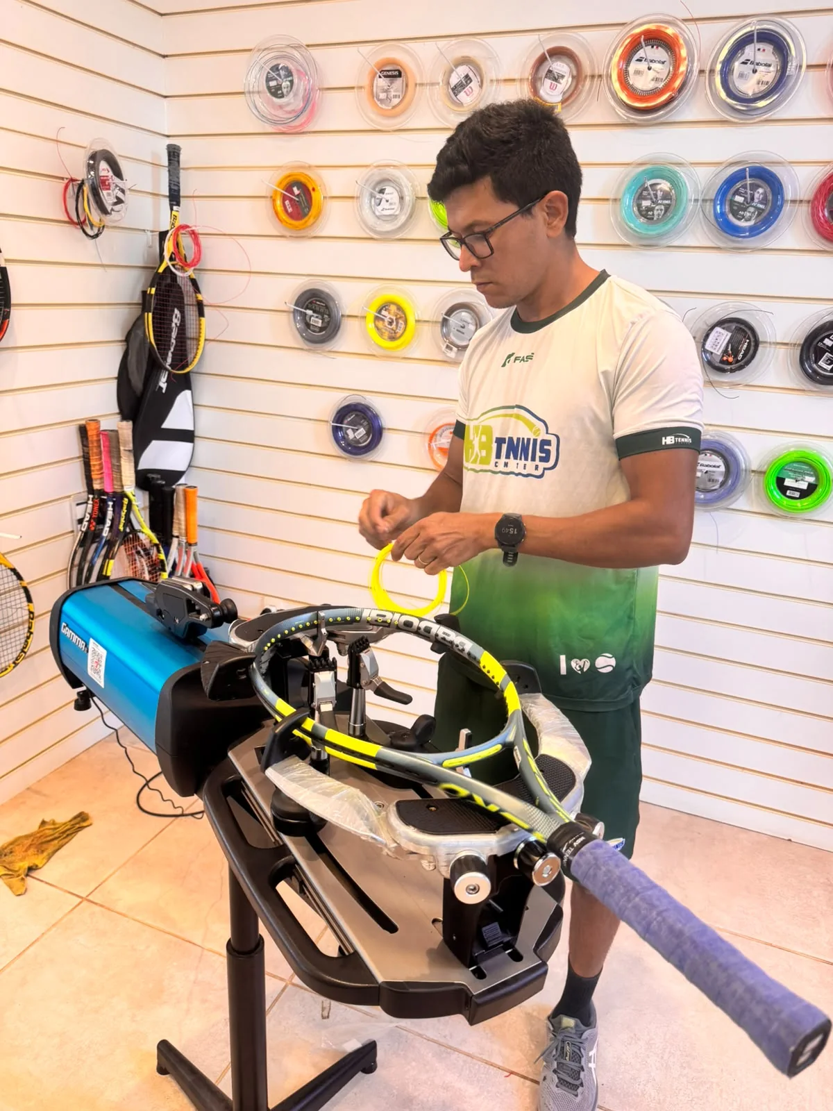 Profissional da HB Tennis realizando o encordoamento de uma raquete